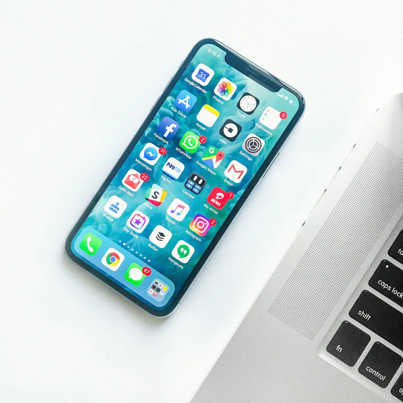 Smartphone and laptop on a white desk