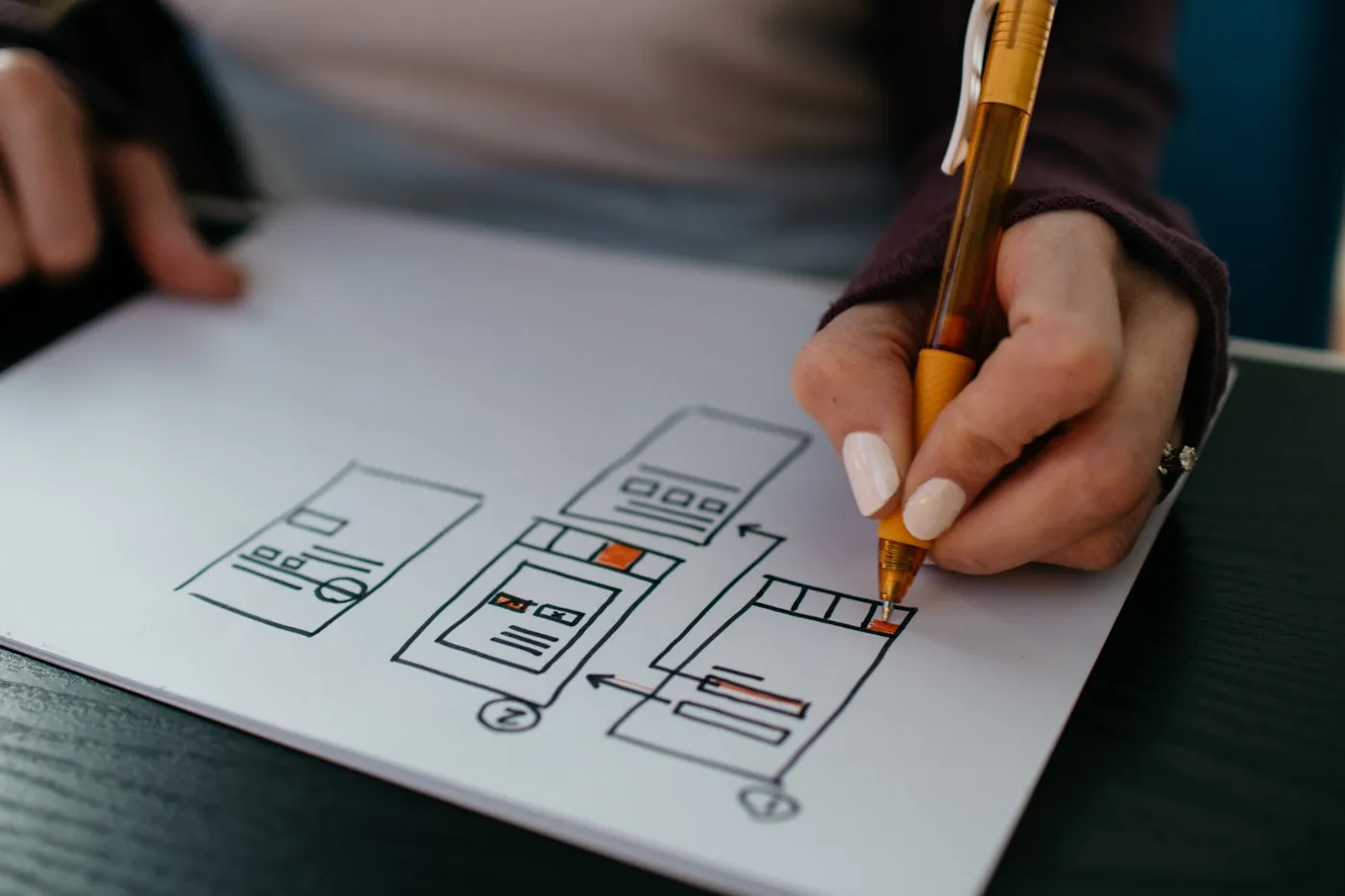 Hand sketching interface wireframes on paper